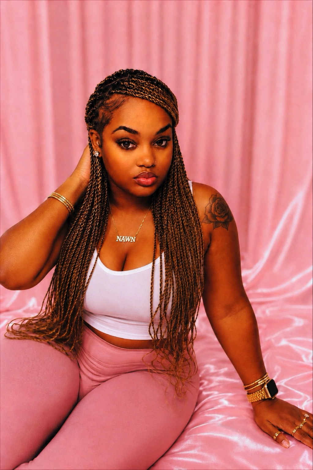 Nana, founder of Frosted Flame, seated against a soft pink satin backdrop